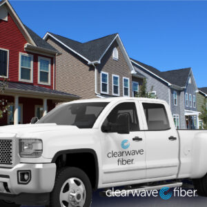 White truck with Clearwave Fiber logo parked outside a row of homes