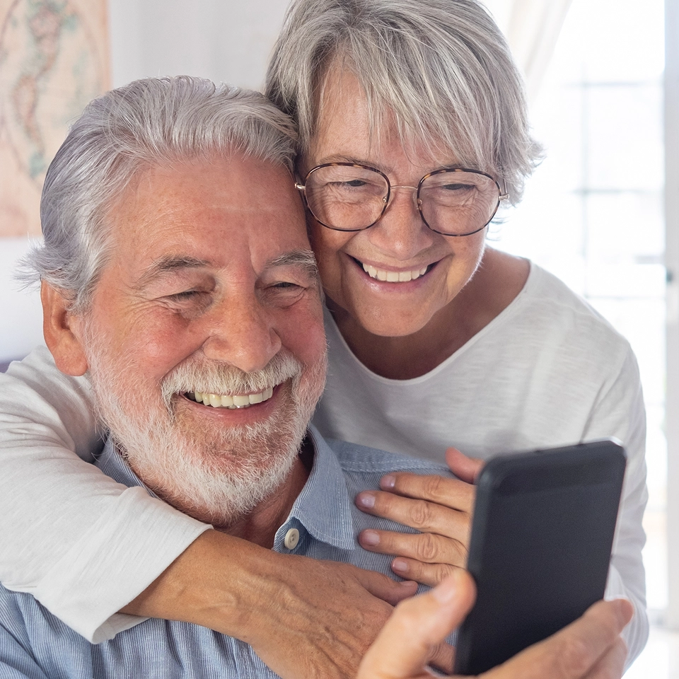 Senior couple using smart phone.